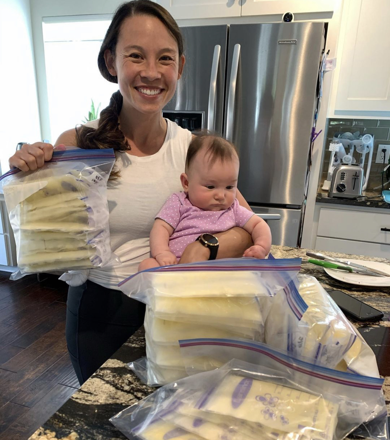 mom and baby holding breast milk bags